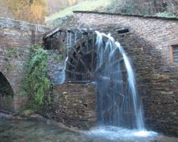 Rueda hidráulica junto al edificio de piedra del museo